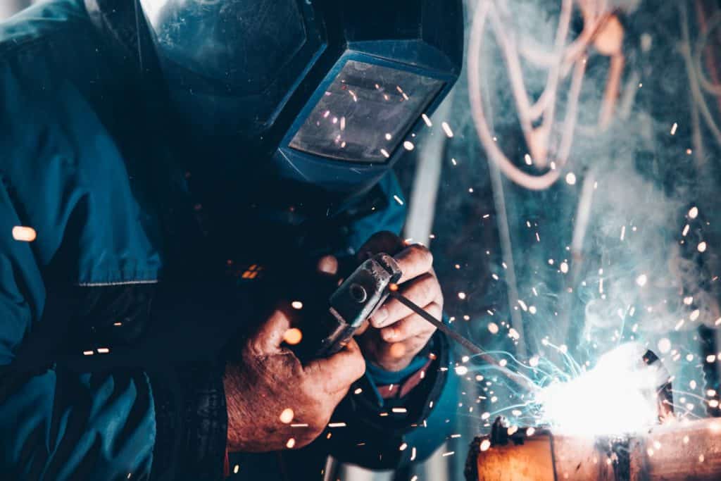 worker welding metal with sparks flying